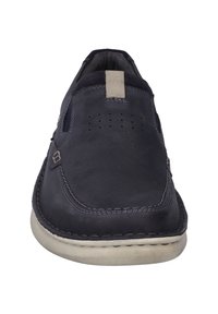Zapatos slip-on de cuero navy con puntera redondeada, costuras decorativas, recortes para ventilación y una suela de goma beige en contraste.
