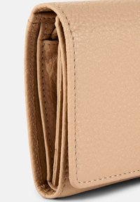 Portafoglio piegato in pelle beige con superficie texture, cuciture dettagliate e bordi ben rifiniti, che mette in mostra un design minimalista.