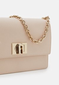 Beige Handtasche aus Leder mit strukturierter Oberfläche, goldener Kettenriemen und goldenem Verschlussdetail auf der Vorderseite. Kompakte rechteckige Form.