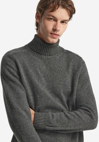 Grauer Rollkragenpullover mit geripptem Kragen und Bündchen, gestrickte Textur, lässige Passform und minimalistisches Design.