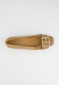 Chaussure plate en daim couleur fauve avec un bout carré et un détail de boucle sur la bride. Texture lisse avec une semelle intérieure rembourrée et un design minimaliste.