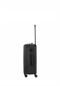 Black hard-shell suitcase with vertical ridges, retractable handle, and four wheels. Features a zipper and lock mechanism.