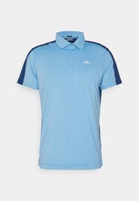 Ljusblå pikétröja med mörkare blå detalj på axlarna, tillverkad av mjukt tyg, med treknappars knappslå och logotyp på bröstet.