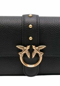 Borsa a mano nera in pelle con una finitura strutturata, una chiusura in metallo dorato con due accenti a forma di uccello e borchie dorate decorative.