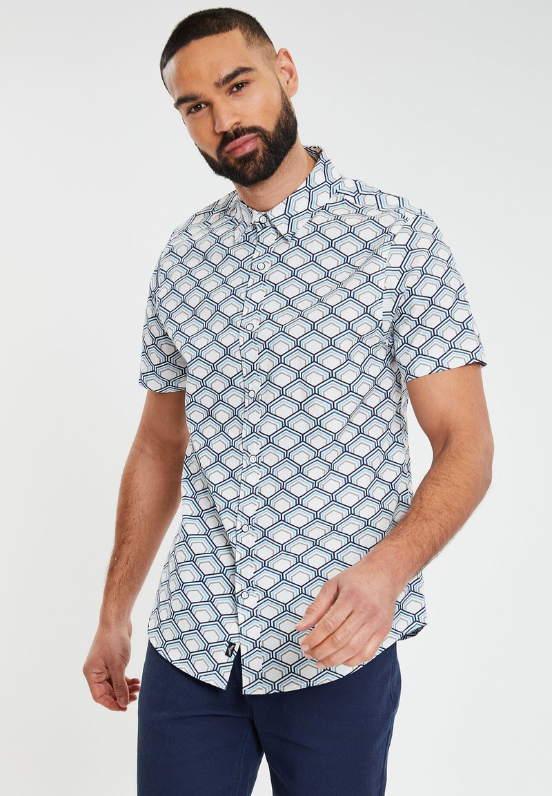 Korte mouwen overhemd met knopen met een witte basis en een geometrisch patroon in marineblauw en lichtblauw. Glad materiaal met een klassieke kraag.
