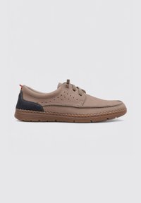 Chaussure en cuir marron clair avec une touche de marine, à bout rond, détails perforés et semelle flexible avec des coutures tout autour.
