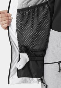 Zwart-wit jacketinterieur met een gaasvak met een honingraatpatroon. Gladde stof met een ritssluiting en een verstelbare trekkoord.