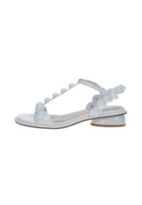 Sandal bianco con design a T-strap, con palline lucide come dettagli, tacco basso e soletta liscia. Realizzato in materiale sintetico.