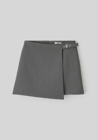 Jupe A-line grise en tissu texturé, avec un détail de boucle sur le côté et un léger pli, offrant un design moderne et élégant.