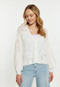 Bílý pletený cardigan s výstřihem do V, širokými rukávy a zapínáním na knoflíky. Disponuje texturovaným, otevřeným pletením a žebrovaným lemem.