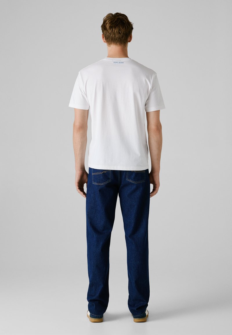 Biała bawełniana koszulka z krótkim rękawem i napisem "PEPE JEANS" z tyłu, w połączeniu z luźnymi, ciemnoniebieskimi dżinsami.