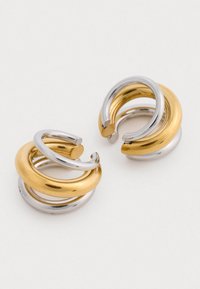 Arany és ezüst színű fémpalarcok, csavart formával, sima felülettel és átfedő kör alakú mintákkal.