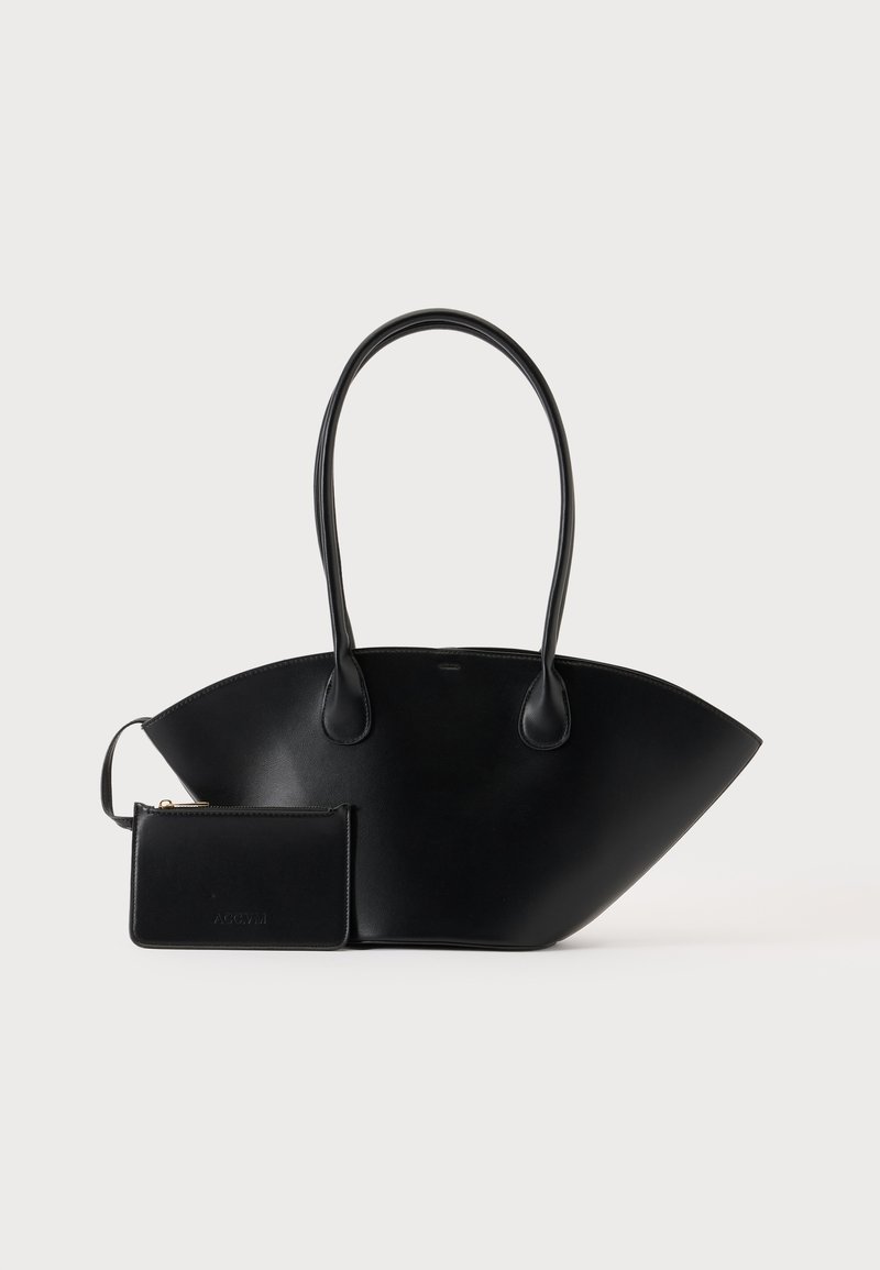 Sac à main en cuir noir avec de longues anses et une petite pochette assortie zippée sur un fond uni.