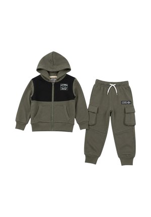 Survêtement enfant vert olive avec veste à capuche zippée, avec un panneau noir sur la poitrine, et pantalon cargo avec poches latérales et taille à cordon.