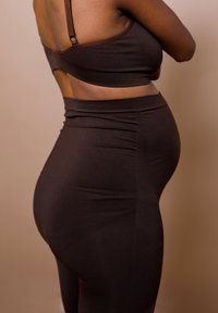 Bruine geribbelde bralette en high-waisted leggings met een gladde textuur, een aansluitend ontwerp en een naadloze uitstraling, met een hoge taille en een uitsnijding op de rug.