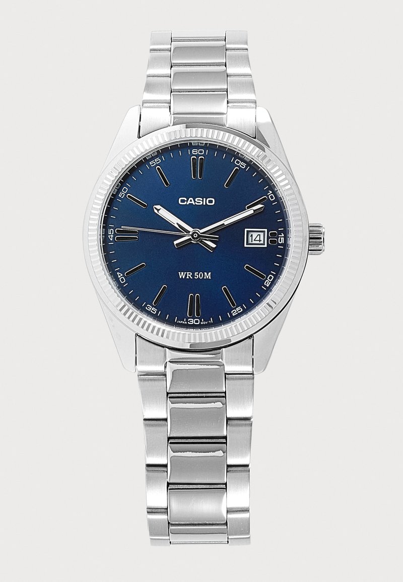 Montre-bracelet Casio argentée avec cadran bleu, index argentés, guichet date affichant le 14 et bracelet métallique à maillons.