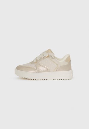 Beige sneakers met een glanzende afwerking, voorzien van een gestructureerd design, touwveters en een dikke, gestructureerde rubberen zool met een subtiel logo.