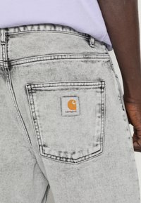 Carhartt WIP NEWEL PANT - Calças de ganga de corte afunilado - black sun washed