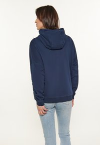 Felpa con cappuccio blu navy dal taglio relaxed, dotata di cappuccio con cordino, polsini e orlo a costine, realizzata in tessuto morbido e spesso.