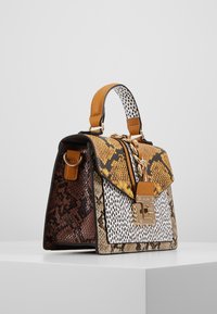 Rakennettu käsilaukku, jossa on sekoitus teksturoituja käärmeennahkakuoseja ruskeassa, keltaisessa ja valkoisessa, joita täydentävät kultaketju ja nahkaosat.