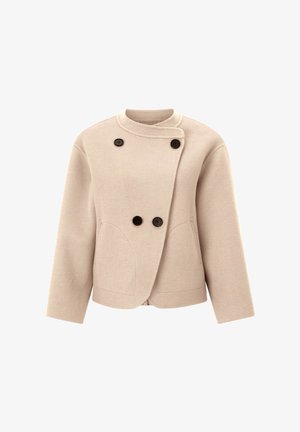 Beige Cropped-Jacke mit hohem Kragen, doppelt knöpfbarem Vorderteil, schwarzen Knöpfen und seitlichen Taschen; aus einem weichen, strukturierten Stoff gefertigt.