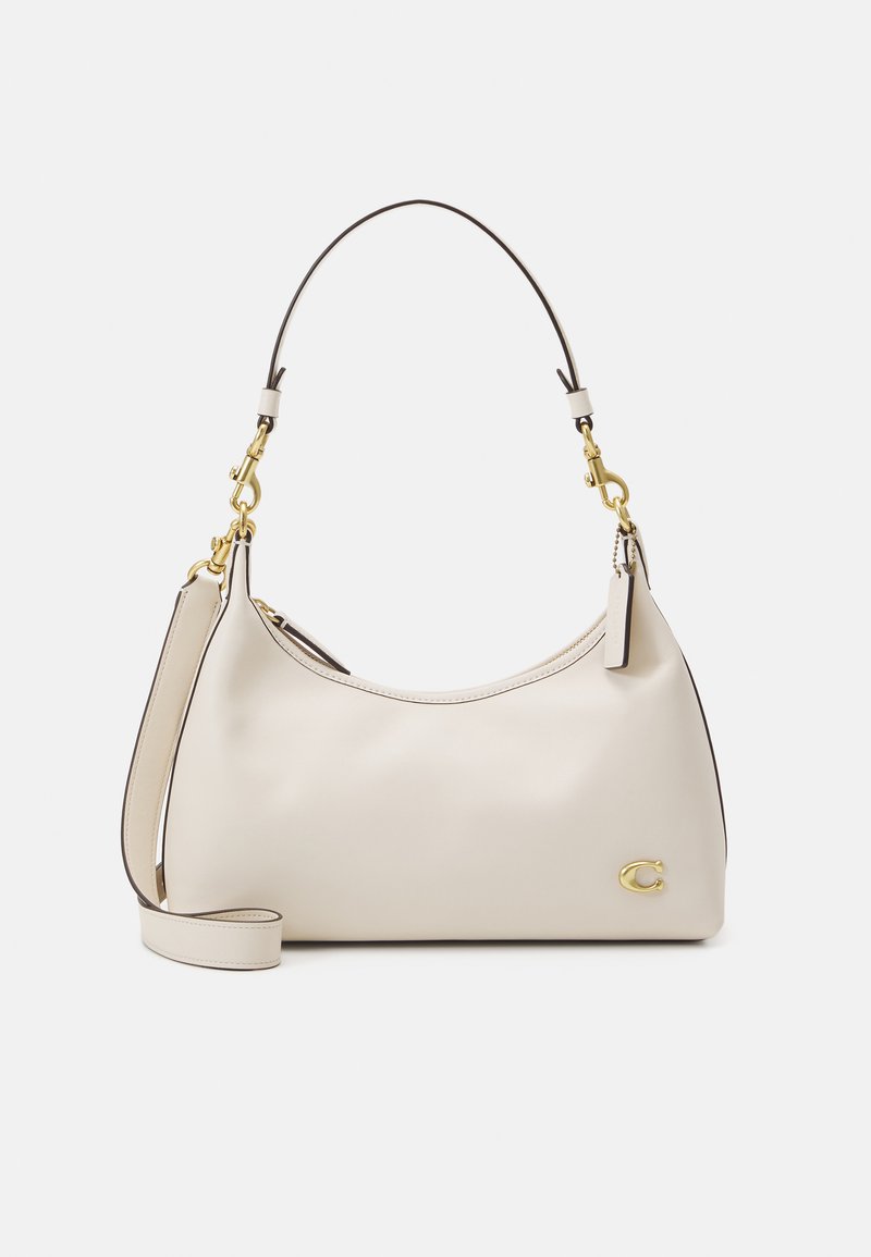 Beige leather handbag with a curved design, gold hardware accents, single shoulder strap, and a small logo detail on the front.
