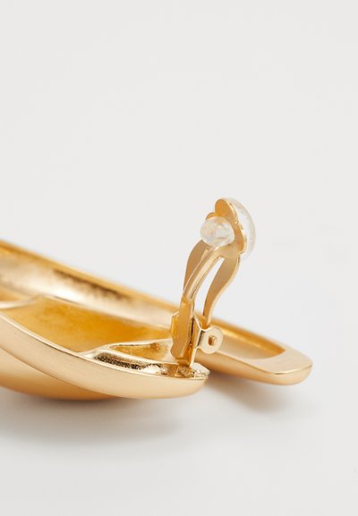 Gouden metalen haarspeld met een glad, gebogen ontwerp, voorzien van een heldere edelsteenaccent en een stevige sluitmechanisme.