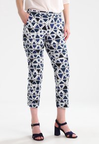 Blå och vita byxor med ett geometriskt triangelmönster, knälängd, med sidofickor och en åtsittande midjeband.
