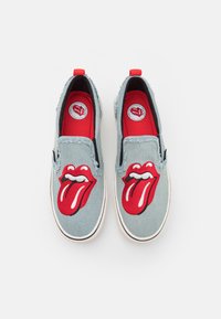 Modré denimové slip-on boty se červeným a bílým logem jazyka Rolling Stones na nártu a červenou stélkou, s třepícími okraji.