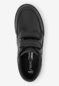 Chaussure en cuir noir avec deux bandes auto-agrippantes, un col rembourré et des détails texturés, étiquetée "next Ultra" et taille "12F" à l'intérieur.