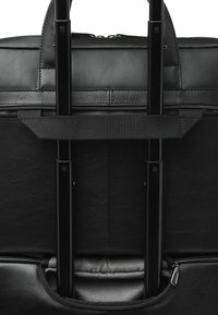 Zwarte leren reistas met uitschuifbare metalen handvatten, ritsvakken en een duurzame voering met een subtiel patroon.