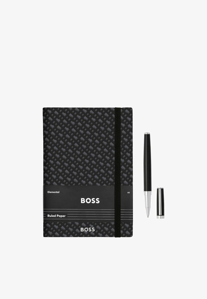 Cahier BOSS noir à motifs avec élastique et un stylo noir à pointe argentée et capuchon détaché sur fond blanc.