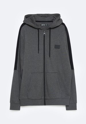 Halli halliga kapuutsiga hall zip-up dressipluus, mustade külgpaneelidega, kahe ees oleva taskuga ja väikese logoplaadiga rinna piirkonnas. Pehme kangatextuur.