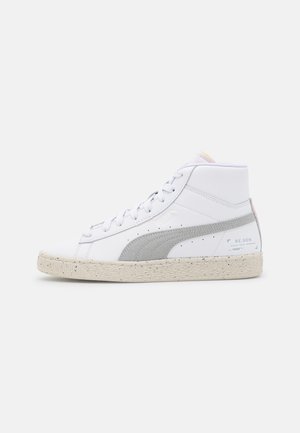Baskets blanches montantes avec une bande Puma gris clair, une semelle beige tachetée et le logo "RE.GEN" sur le côté du talon, vues de profil.