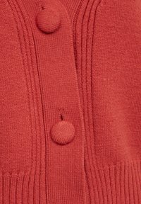 Rode gebreide cardigan met twee ronde knopen, verticale ribbels langs de voorkant en een zachte, comfortabele stof.