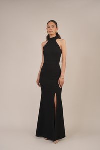 Svart kveldskjole med tettsittende overdel, halterneck og en høyt splittet skjørt. Det glatte stoffet og gulvlange designet fremhever dens elegante silhuett.