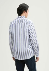 Gestreept overhemd met lange mouwen in wit, blauw en paars. Voorzien van een button-down kraag, achterpand en knoopmanchetten. Gladde stoftextuur.