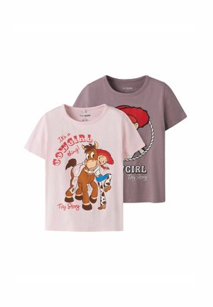 Deux t-shirts à manches courtes avec des graphismes de personnages : un rose avec une cowgirl et un cheval, et un gris avec une cowgirl en train de lasso, tous deux en coton.