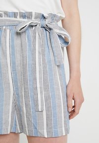 Blå och vita randiga shorts i ett texturerat material, med ett matchande bälte och sidfickor.