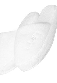Vita spa-tofflor tillverkade av mjukt, fluffigt material med en rundad design, texturerad yta och subtilt broderad logotypdetalj.