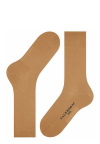 Chaussettes de couleur tan en tissu lisse, avec un bord côtelé, un talon et un orteil renforcés, et un logo imprimé au fond.