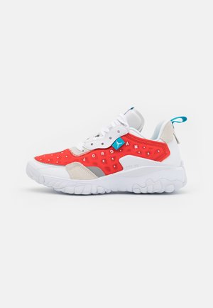 Baskets blanches et rouges avec semelle texturée, lacets blancs, languette bleue et petit logo Jordan sur le côté.