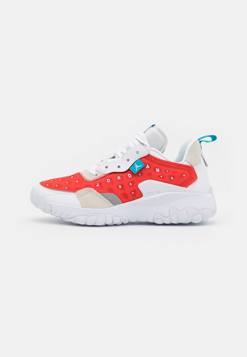 Baskets blanches et rouges avec semelle texturée, lacets blancs, languette bleue et petit logo Jordan sur le côté.