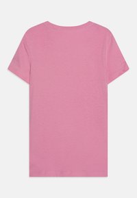 Camiseta de manga corta rosa hecha de algodón suave, con cuello redondo y diseño liso, que presenta una textura suave y sin adornos.