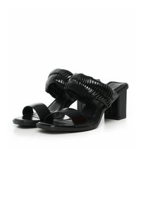Sandales à talons hauts noires avec de larges lanières tressées, conception à bout ouvert et talon bloc. Texture lisse et finition brillante.