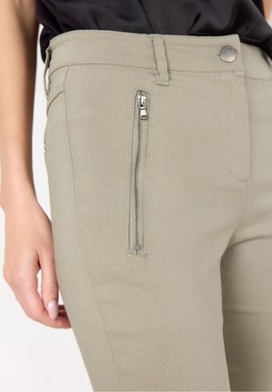 Pantaloni verde chiaro realizzati in tessuto misto cotone con una texture liscia. Presentano una tasca con zip laterale e un bottone in metallo in vita.