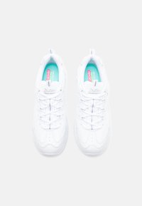 White athletic shoes with a textured leather upper, padded collar, and flat laces. Inside features a light blue insole with pink accents.