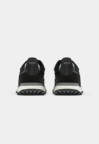 Czarne buty sportowe z teksturowaną cholewką, szarymi akcentami i wyściełaną białą podeszwą. Posiadają logo na pięcie oraz trwały wzór bieżnika.
