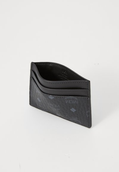 Svart lærpung med strukturert overflate, som har et subtilt preget mønster, to kortlommer og en buet toppdesign.