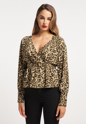Bluse med leopardprint og dyb V-hals, lange ærmer og indsnøret talje. Svingende stof i nuancer af brun og guld. Sorte tætsiddende bukser.